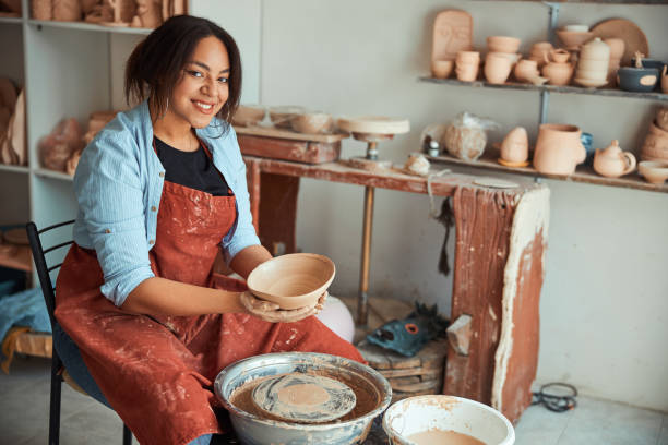 istock Joyful young woman ceramist working in pottery workshop 1319481701