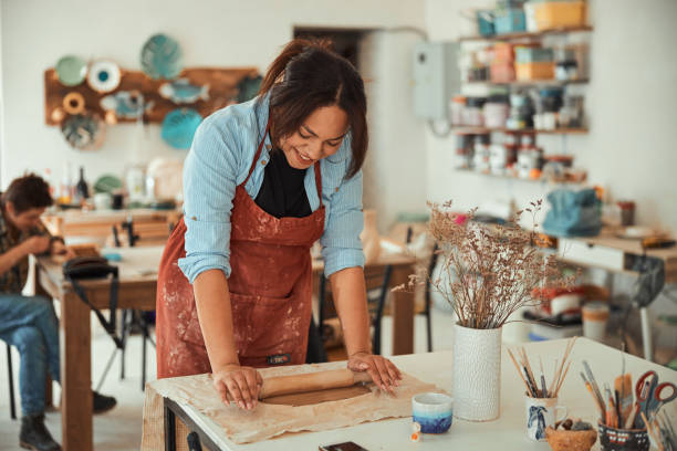 istock Cheerful craftswoman in apron working in pottery workshop 1319481720