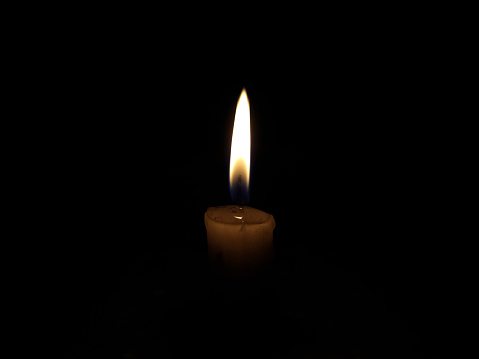 candle burning in the dark, yellow flame