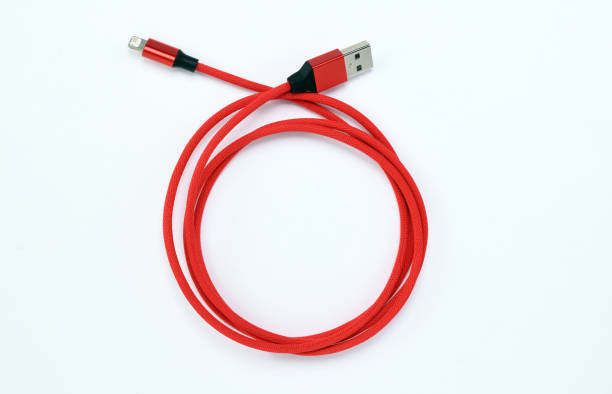 istock Detail of a red USB cable connector for a mobile phone on a white background. 1319482987