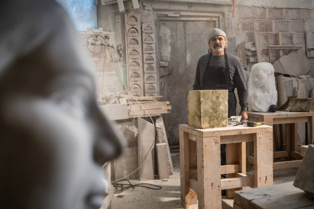 istock Stonemason in his studio with a piece of raw stone 1319483985