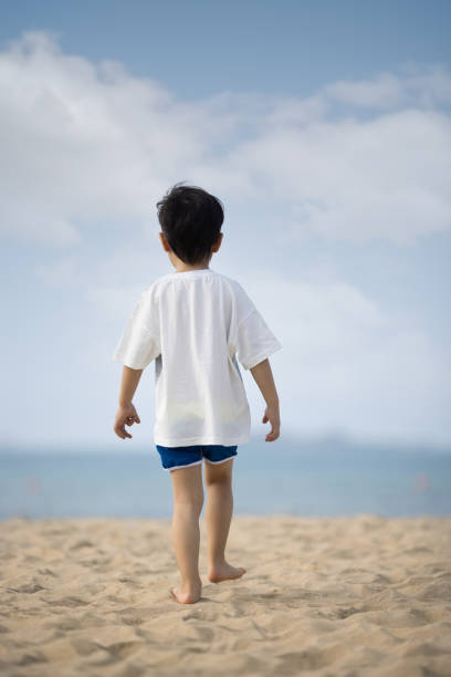 Asian boy playing on the beach