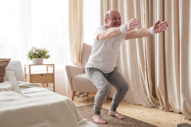 istock Senior man practicing yoga at home doing Chair pose, Utkatasana 1319484284