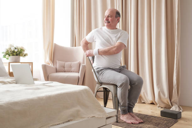 istock Sporty senior man practicing yoga using chair, doing Parivrtta Utkatasana 1319485721