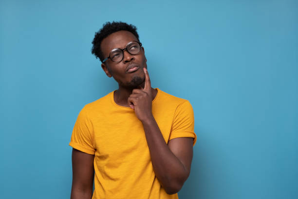 istock Young african man in glasses thinking over blue background 1319486513
