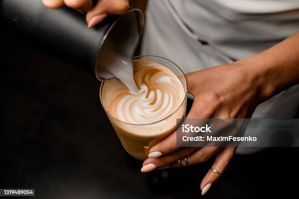 Closeup Of Woman Who Beautiful Drawing Pattern Pouring Milk Into Glass With Latte Stock Photo - Download Image Now