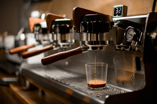 istock professional coffee machine automatically prepares and pours espresso drink into clear glass 1319490265