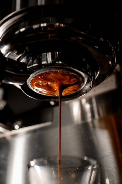istock Delicious freshly ground espresso pouring through bottomless portafilter into glass. 1319490921