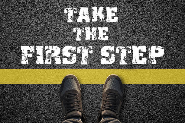 Take the first step text and sneakers on the asphalt ground