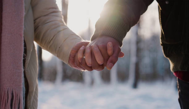 istock holding hands in the park 1319496177