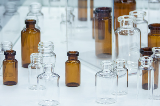 Group of empty medicine bottles made of clear and brown glass, low-grip