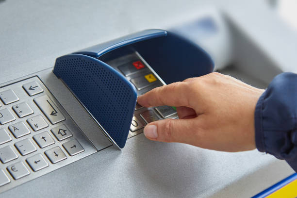 A female hand dials a personal code on the ATM keyboard openly. The concept of lack of caution, carelessness, money transfers and theft of personal information. Close-up A female hand dials a personal code on the ATM keyboard. The concept of safe use of bank cards, deductible funds, the wholesale of services and goods, receiving cash. easy button image stock pictures, royalty-free photos & images