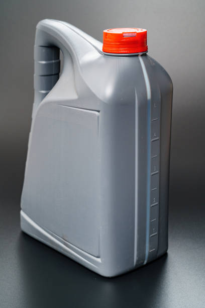 istock grey with a red lid canister with machine oil on a black background. 1319516306
