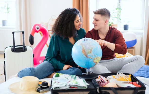 istock Young couple with map packing for holiday at home, new normal. 1319524161