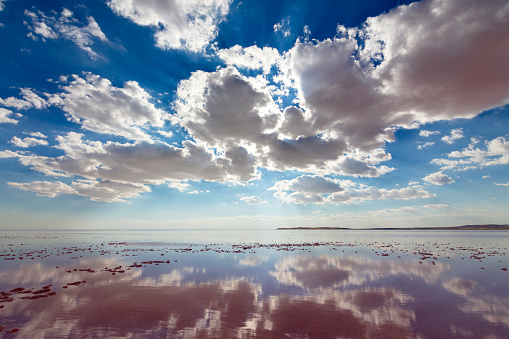 futuristic background consisting of Time lapse clip of white fluffy clouds over blue sky and their reflection, video loop. 4k.