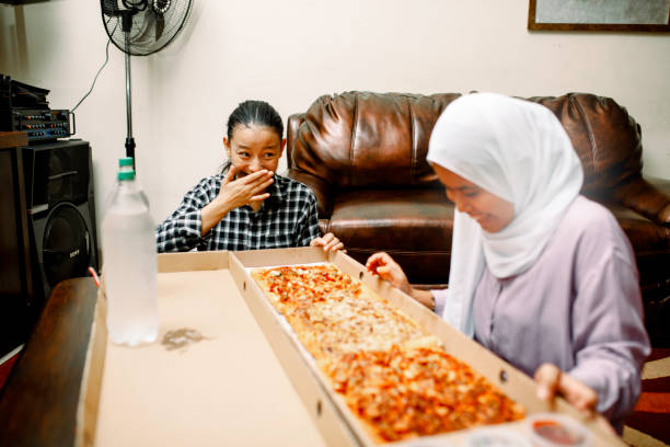 istock young muslim women having breakfast with pizza at ramadan 1319535707