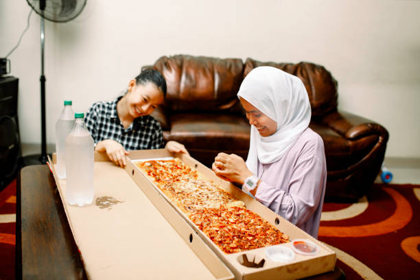 istock young muslim women having breakfast with pizza at ramadan 1319535726