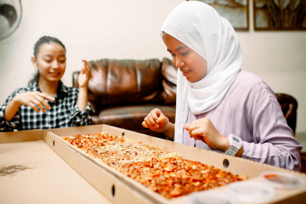 istock young muslim women having breakfast with pizza at ramadan 1319535735