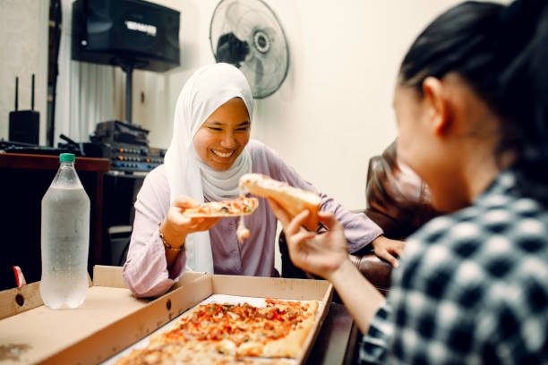 istock young muslim women having breakfast with pizza at ramadan 1319535744