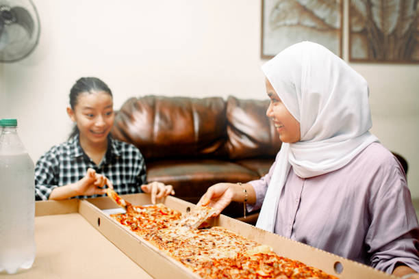 istock young muslim women having breakfast with pizza at ramadan 1319535751