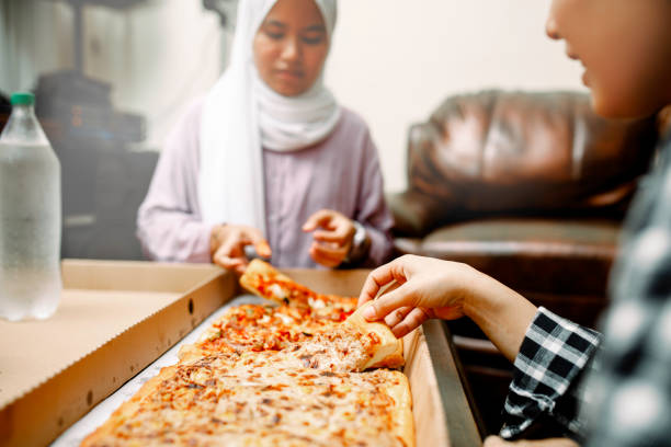 istock young muslim women having breakfast with pizza at ramadan 1319535758