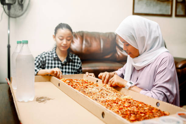 istock young muslim women having breakfast with pizza at ramadan 1319535773