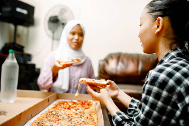 istock young muslim women having breakfast with pizza at ramadan 1319535777