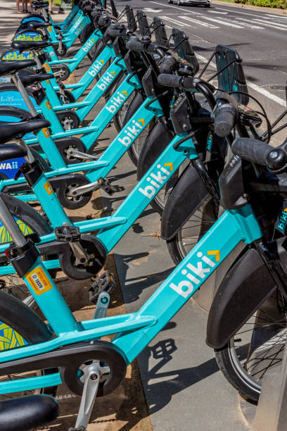 Row of Biki Bikes in Waikiki, Honolulu, Hawaii Honolulu, Hawaii- Jan 25, 2019: Biki Bikes is Honolulu, Hawaii's bicycle sharing program bicycle docking station stock pictures, royalty-free photos & images