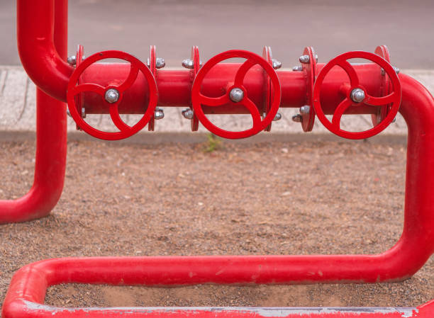 istock Fire safety system. Three consistent valves with red pipes for water. Outdoors. Close-up. 1319543280