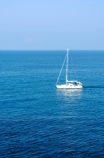 Sea view and white yacht without sails in the distance, vertical format