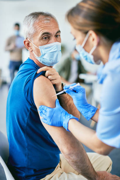 istock Mature man getting vaccinated against COVID-19 at vaccination center. 1319550868
