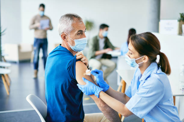istock Mature man getting adhesive bandage on his shoulder after coronavirus vaccination. 1319550936