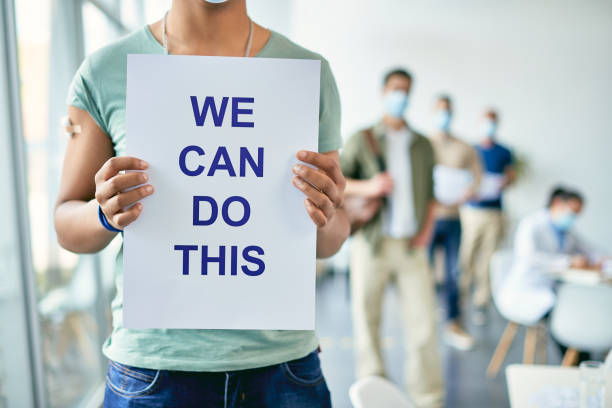 istock Unrecognizable African American man holding placard with supportive 'we can do this' message at COVID-19 vaccination center. 1319551030