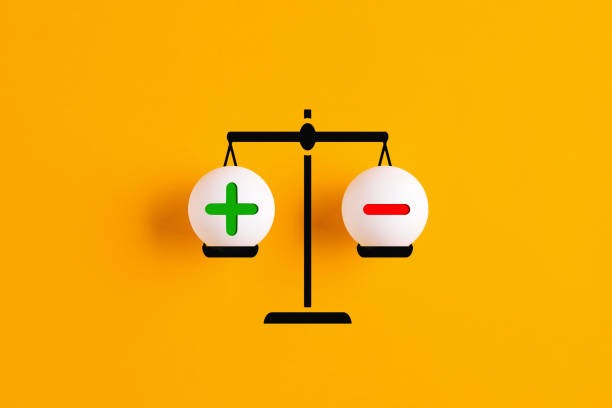 Plus and minus or positive and negative symbols are in balance on a scale. Plus and minus or positive and negative symbols are in balance on a scale with yellow background. subtraction stock pictures, royalty-free photos & images