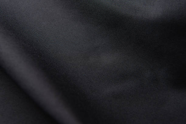istock Closeup of rippled black silk fabric, black fabric texture background, 1319555183