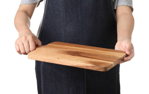 istock Chef holding wooden cutting board isolated on white background 1319555822