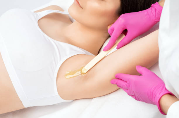 un esteticista hace una depilación de pasta de azúcar debajo de las axilas en un salón de belleza. cosmetología estética femenina. - waxing armpit women beauty treatment fotografías e imágenes de stock