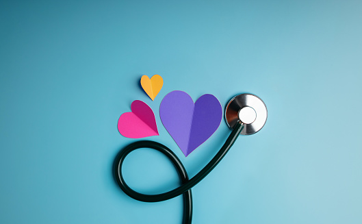 Health Care Concept. International World Heart Day. Paper Cut as Heart Shape with Stethoscope lay on Blue background. Life, Love and Care. Top View