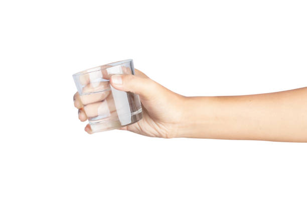 istock Hand holding water glass isolated on white background. 1319564148