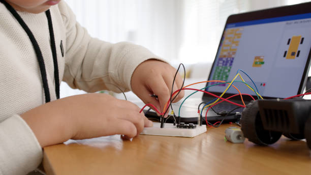 istock Young asia student remotely learn online at home in coding robot car and electronic board cable in STEM, STEAM, mathematics engineering science technology computer code in robotics for kids concept. 1319565341