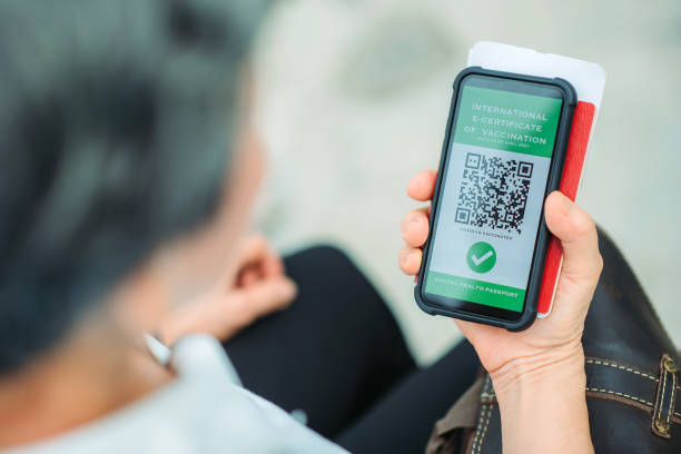 istock Asian chinese active senior women looking down on a digital vaccine certificate on her smartphone while waiting on border control 1319573232