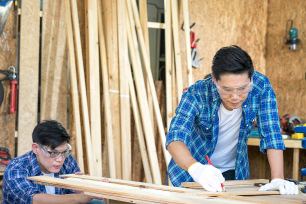 istock Young Carpentry workshop's boss woodworking. Wood processing apprenticeship at carpentry shop. 1319574459