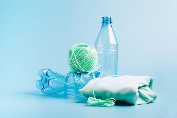 le concept de recyclage du plastique. bouteille en plastique vide et fibre recyclée de polyester, fond bleu synthétique de tissu - polyester photos et images de collection