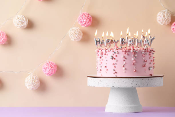 istock Birthday cake with burning candles on violet table, space for text 1319576899