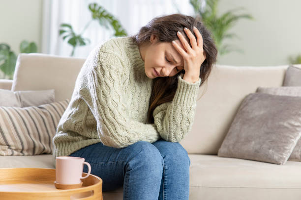 istock Depressed young woman on sofa at home 1319577116