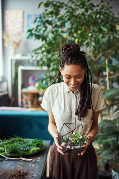 istock Joyful woman demonstrating a polyhedron succulent terrarium 1319577194