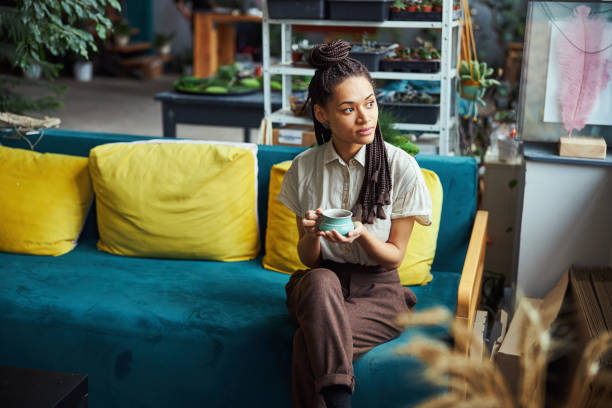 istock Thoughtful florist with a cup in her hands looking away 1319577196