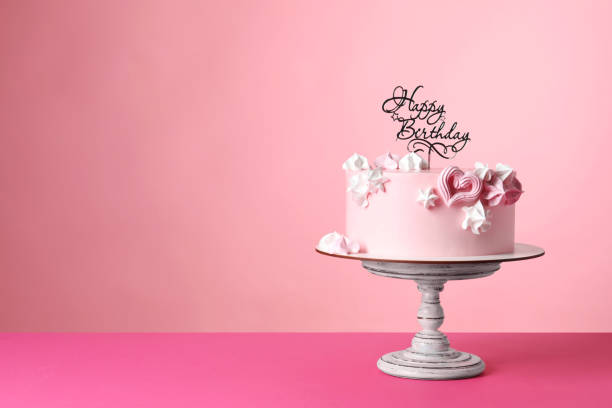 istock Beautifully decorated birthday cake on pink background, space for text 1319577259