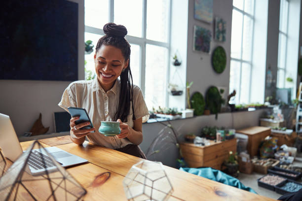 istock Happy florist reading a text message during the tea break 1319577328
