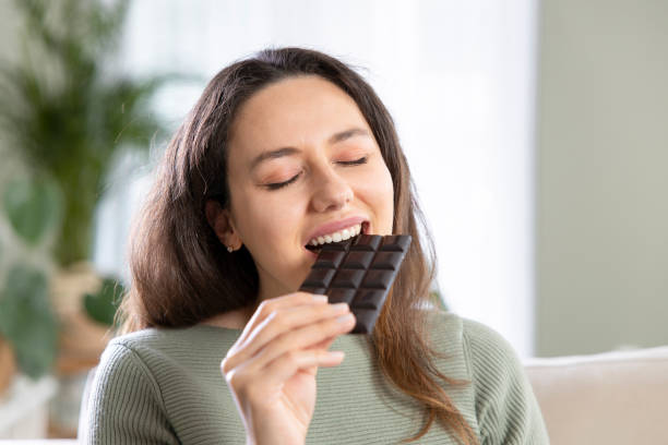 istock Woman biting a chocolate bar 1319577367